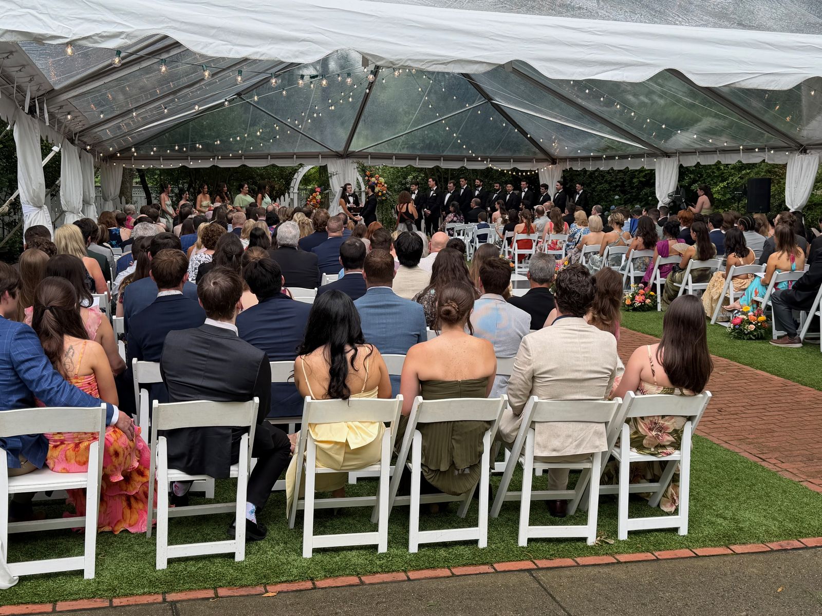 Guests seated for an outdoor tented wedding ceremony
